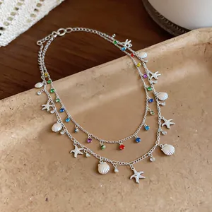 Dettaglio della collana a doppio strato con stelle marine, conchiglie e strass colorati