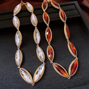 Detail of vintage gold necklace featuring marquise clear and amber faceted crystals