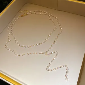 Dettaglio di una collana a due strati con perle e nappe di perline di cristallo.