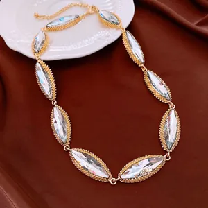 Detailed view of the sparkling oval crystal necklace on a warm brown silk background