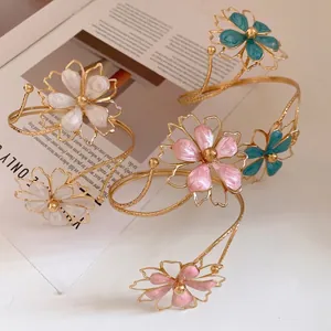 Vintage style gold metal arm cuff bracelet featuring colorful enamel flower charms