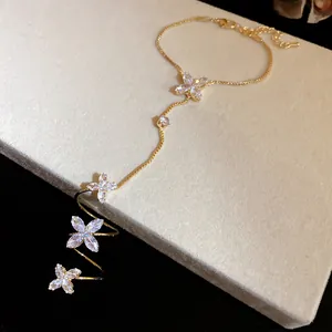 Close-up of sparkling zircon flower bracelet with elegant gold-plated hand chain design