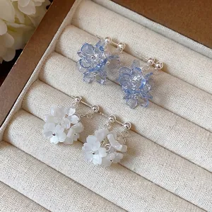 Elegant blue and white resin floral cluster stud earrings presented in a jewelry box