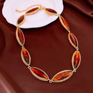Detailed view of a vintage gold necklace with marquise-cut amber crystals on brown silk