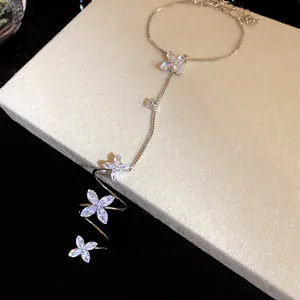 Detailed macro view of sparkling cubic zirconia flower charms on a delicate silver chain.
