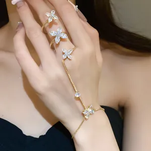 Close-up of gold hand harness set with sparkling marquise zircon butterfly motifs.