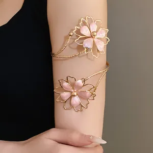 Close-up of elegant gold metal armlet featuring pink enamel flower designs