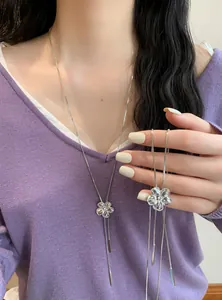 Détail du collier à pampilles en fleurs de cristal avec un haut en maille violette