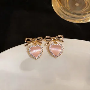 Elegant pink heart cat eye stud earrings with gold bow and sparkling rhinestone halo