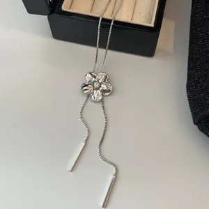 Vue détaillée du collier fleur argenté avec strass et élégantes barres de gland