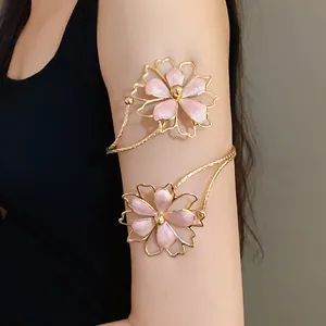 Detailed view of a vintage gold arm cuff with pink enamel flowers on upper model arm