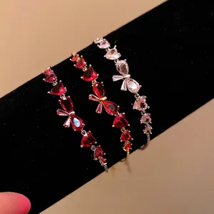 Exquisite zircon bracelets featuring heart and bowknot charms on black velvet stand
