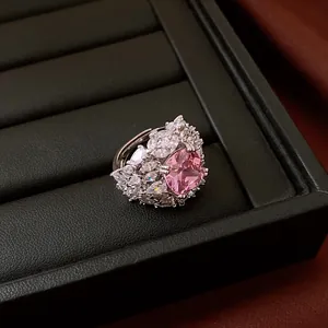 Close-up of pink cubic zirconia open ring with sparkling cluster accents in jewelry box