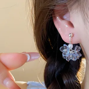 Detailed close-up showing elegant flower pearl stud earrings on an ear for summer look