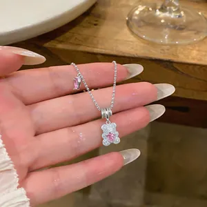 Detailed macro view of silver bear pendant with pink heart zircon and pavé stones