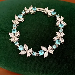 Elegant silver bracelet featuring sky blue and clear cubic zirconia in a floral design