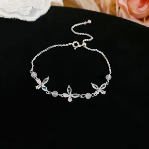 Detailed view of an elegant silver butterfly bracelet with cubic zirconia and white beads