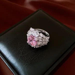 Detail of silver cluster ring with cushion-cut pink zircon on black leather box.