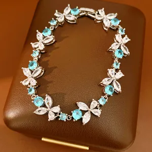 Detailed view of silver-toned floral bracelet with blue and clear zirconia stones