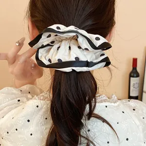 French style polka dot scrunchie hair accessory worn on a ponytail detail