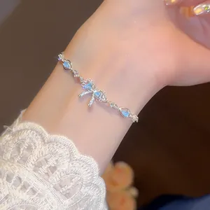 Detail view of an elegant silver bracelet featuring a sparkling blue bow and zircon stones