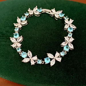 Close-up of silver-plated bracelet with blue and clear zircon floral patterns.
