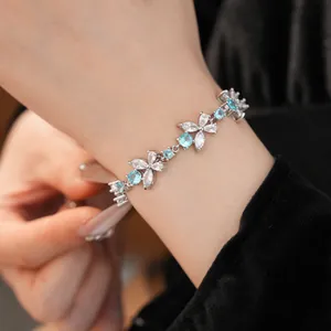 Detailed close-up of an elegant blue flower cubic zirconia bracelet worn on a lady's wrist