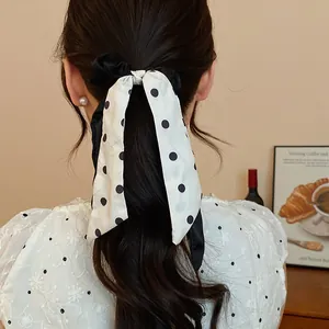 Close-up detail of a vintage polka dot ribbon hair scrunchie styled on a ponytail.