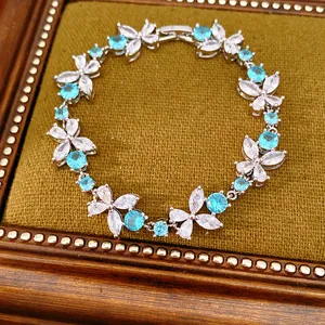 Detailed shot of sparkling blue and white zirconia flower bracelet on velvet tray