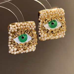 Vintage gold square earrings with pearls and green evil eye design