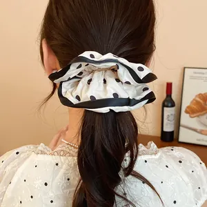 Elegant French style white polka dot hair scrunchie shown in a back view ponytail style