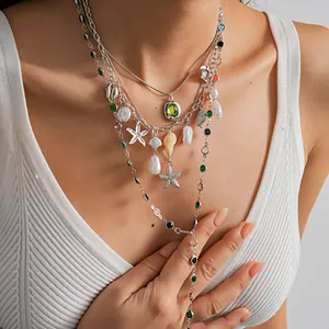 Detailed macro view of a layered pearl and starfish necklace with colorful resin stones.