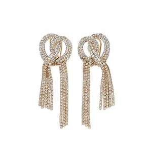 Orecchini a nodo dorati eleganti con lunghe nappe di strass brillanti per donna