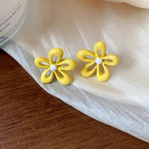 Dettaglio di orecchini a fiore giallo vibrante con finitura smaltata stile dopamina