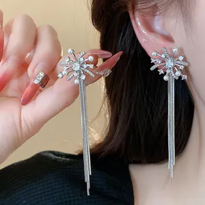 Elegant silver firework tassel earrings with pearls and shining crystals shown on model.