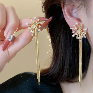 Detailed view of 18k gold-plated firework tassel earrings with pearls and crystals.