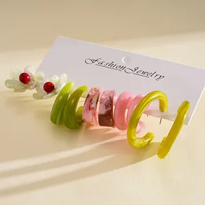 Detail of a 10-piece resin earring set with marble and floral geometric C-shaped designs.