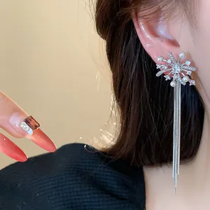 Detailed view of exquisite firework-shaped silver needle earrings with pearls and long tassels