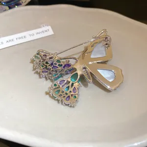 Detailed back view of an elegant butterfly brooch with purple zircon and shell inlay
