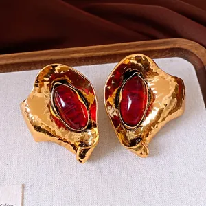 Orecchini dorati vintage con grande pietra in resina rossa e motivo a foglia martellata
