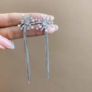 Close-up view of elegant silver firework tassel earrings featuring pearls and crystal accents