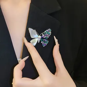 Detailed macro shot of an asymmetrical zircon butterfly brooch on a black blazer