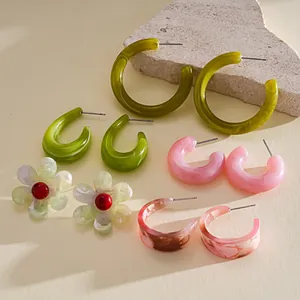 Detailed view of colorful resin earrings set with flower and geometric hoop designs.