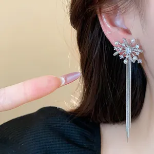 Detailed view of silver firework earrings with pearl tassels and rhinestone accents