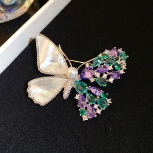 Detailed macro view of the zircon and shell butterfly brooch with pearl center