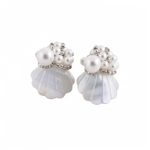 Elegant white shell earrings with clustered pearl beads on a plain white background.