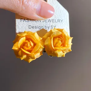 Primo piano di orecchini a lobo a forma di rosa gialla placcati in oro 18K.