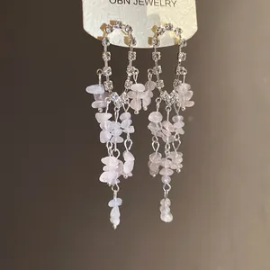 Dettaglio ravvicinato di orecchini a nappa con pietre rosa e strass in argento