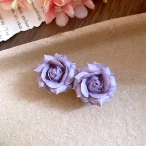 Dettaglio macro di eleganti orecchini a lobo a rosa viola su sfondo di carta kraft