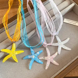 Dettaglio della collana con ciondolo a stella marina in resina e nastro d'organza